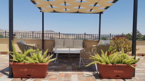 a patio with chairs and potted plants on a roof at Villa dei Mandorli in Naro