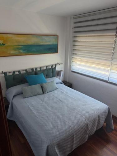 a bedroom with a white bed with a window at Vacaciones Cambrils sol Park in Cambrils