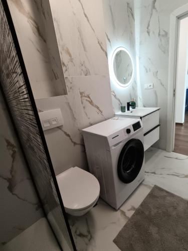 a bathroom with a toilet and a washing machine at B&B ApartHotel in Bistriţa