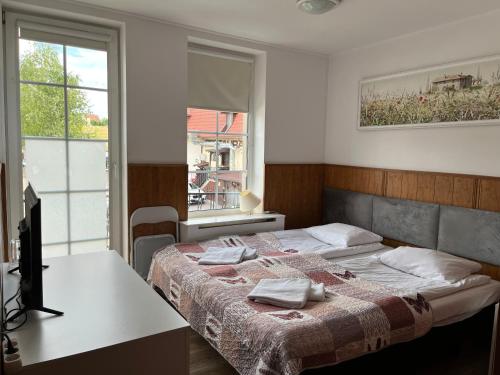 a bedroom with a bed with a table and a window at Prohibicja Peter's Pub in Mikołajki