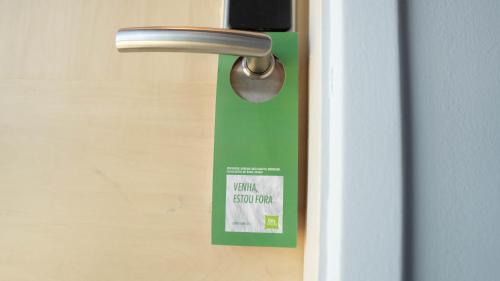 a door with a green door tag on it at Ibis Styles Macaé in Macaé