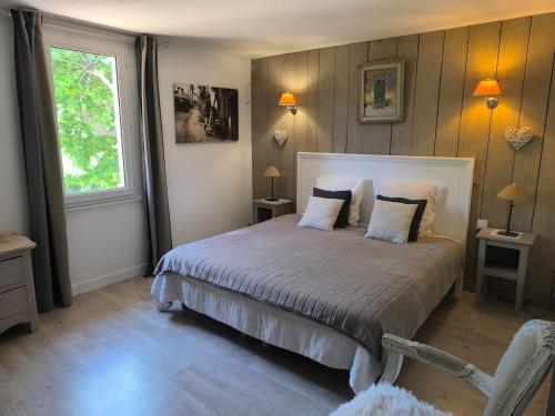 Gîte en Provence في كافايو: غرفة نوم بسرير وطاولتين ونافذة