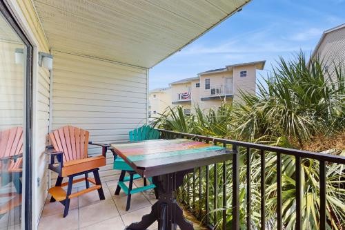 a patio with a table and chairs on a balcony at The Beach Escape in Clearwater Beach