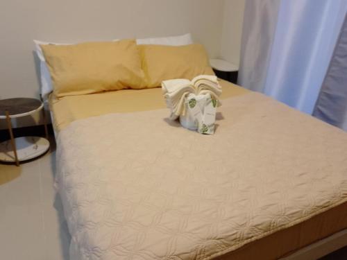 a bed with a towel on top of it at Saekyung Condominium in Basbas