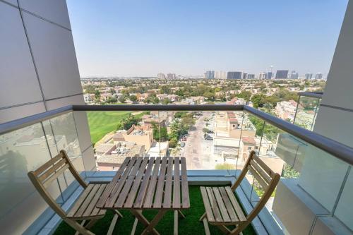 two chairs on a balcony with a view of a city at Luxury Studio - Golf Views - Sports City Dubai in Dubai
