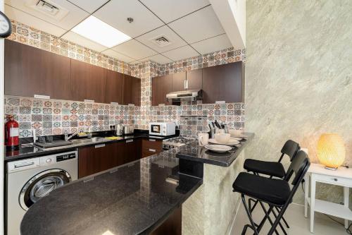 a kitchen with a counter and a dishwasher at Luxury Studio - Golf Views - Sports City Dubai in Dubai