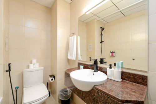 a bathroom with a sink and a toilet and a mirror at Luxury Studio - Golf Views - Sports City Dubai in Dubai