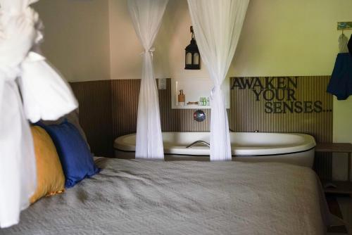 a bedroom with a bed with curtains on it at Xamã Senses - Hotel Pousada in Pipa