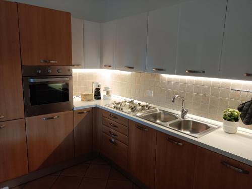 a kitchen with wooden cabinets and a sink at Appartamento Sunflower in posizione soleggiata in Levico Terme