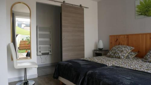 a bedroom with a bed and a mirror and a window at L 'esprit Loft in Montreuil-sur-Maine