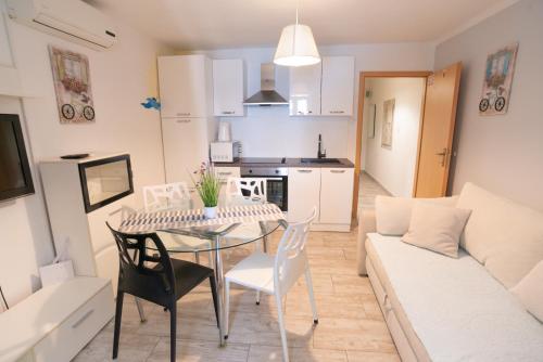 Una cocina y una sala de estar con mesa y sillas. en Apartments Mihael, en Baška