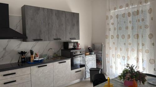 a kitchen with white cabinets and a table and a window at DRIL Host 1 in Brindisi
