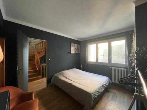 - une chambre avec un lit, une fenêtre et un escalier dans l'établissement Maison de ville dans la baie du Mont Saint Michel, à Avranches