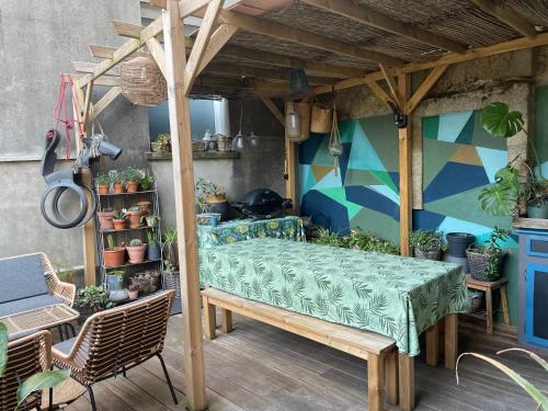 une pergola avec une table et des chaises sur une terrasse dans l'établissement Maison de ville dans la baie du Mont Saint Michel, à Avranches