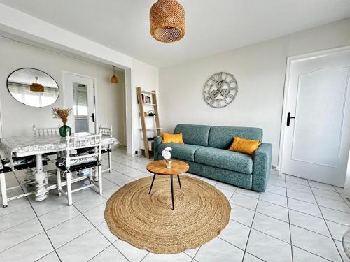 un salon avec un canapé bleu et une table dans l'établissement Le 8 Limougeaud, lumineux et spacieux, à Limoges