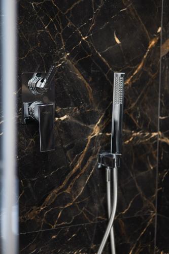 a shower in a bathroom with a granite wall at BeHome in Trani