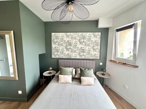 a bedroom with a bed with two tables and a ceiling fan at F3 quartier historique, parking gratuit, vue Saône in Chalon-sur-Saône