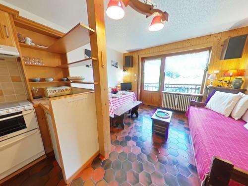 - une cuisine avec un lit et une table dans une chambre dans l'établissement Charmant 2 pièces + mezzanine, centre Chinaillon, balcon sud, parking privé - FR-1-241-190, au Grand-Bornand
