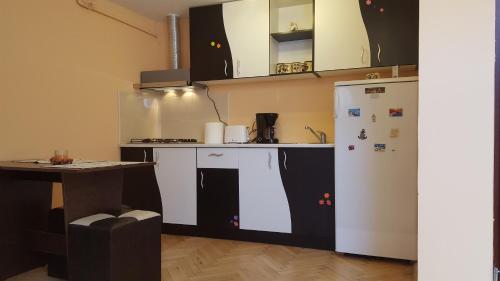 a kitchen with a white refrigerator and a table at Studio Piata Sfatului - Brasov in Braşov