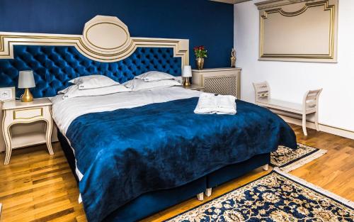 a blue bedroom with a large bed with a blue blanket at Sky Park Home in Iaşi