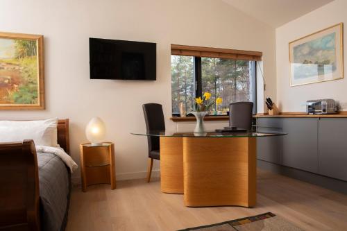 a room with a table with a vase of flowers on it at studio in the wood in Duirinish