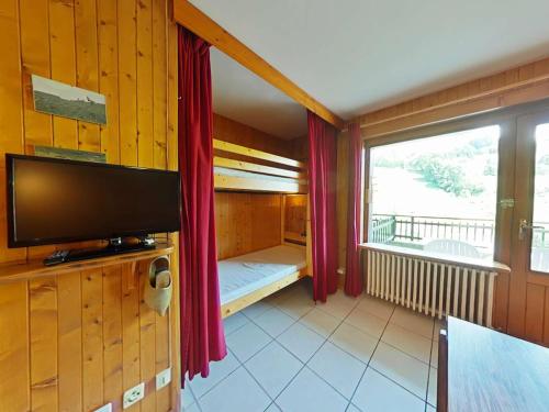 un salon avec une télévision et une grande fenêtre dans l'établissement Studio cosy 4 pers, au centre, près des pistes - FR-1-241-114, au Grand-Bornand