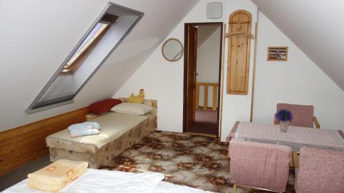 a attic room with a bed and a window at Chalupa Obora in Cerhonice