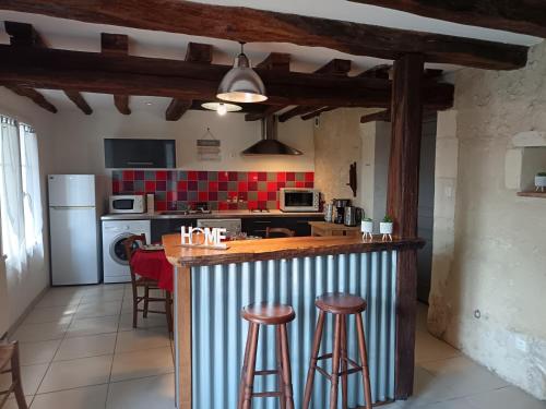 eine Küche mit Theke und Hockern in einem Zimmer in der Unterkunft Mielogite in La Croix-en-Touraine