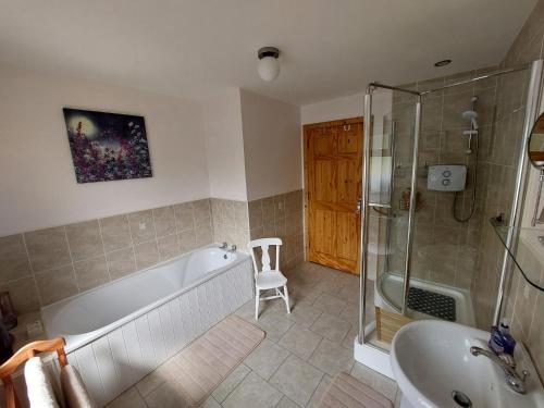 a bathroom with a tub and a shower and a sink at Melleray Heights in Cappoquin