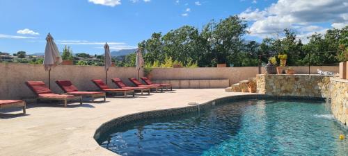 a swimming pool with chairs and umbrellas on a patio at Villa Martinus in Saint-Paul-de-Vence