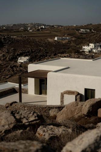 a white house on top of a hill with rocks at Armacaas Mykonos Hotel in Super Paradise Beach