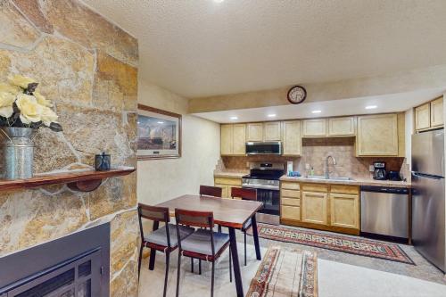 a kitchen with a wooden table and a fireplace at Ten Mile Haus in Frisco