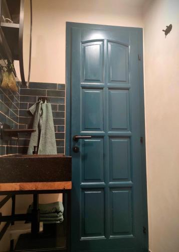 a blue door in a bathroom with a sink at Prospect in Motovun