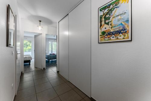 a hallway with white walls and a painting on the wall at Appartement T3, Bassin D'arcachon in Andernos-les-Bains