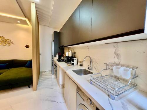 a kitchen with a sink and a counter top at Bright Corniche Escape - 2 BR Urban Flat in Tangier
