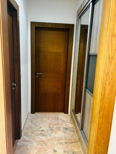 a hallway with a wooden door and a tile floor at Appartement S1 Haut Standing Monastir in Monastir