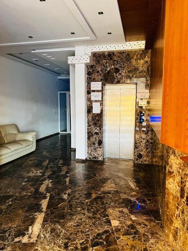 a lobby with a couch and a stone wall at Appartement S1 Haut Standing Monastir in Monastir