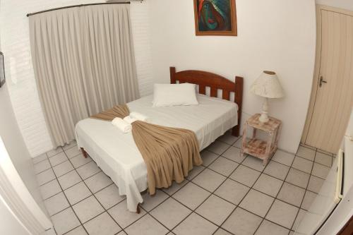 a bedroom with a bed with a blanket on it at Pousada Don Alberto's in Florianópolis
