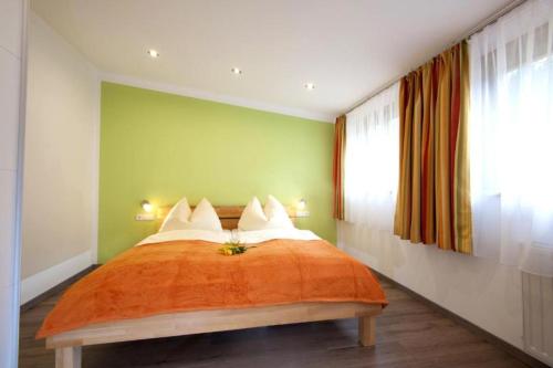 a bedroom with a bed with green walls and a window at AlpinSpa zur Post Apartment - Bergbahn im Sommer 2025 inklusive in Bad Gastein