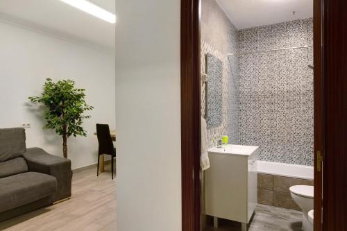 a bathroom with a couch a sink and a toilet at Apartamento Casa Italia in Vecindario