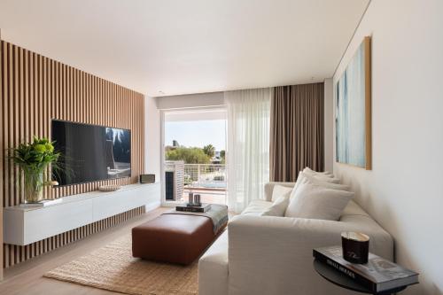 a living room with a white couch and a tv at 1bd Sv Beach Condo With Pool in Athens
