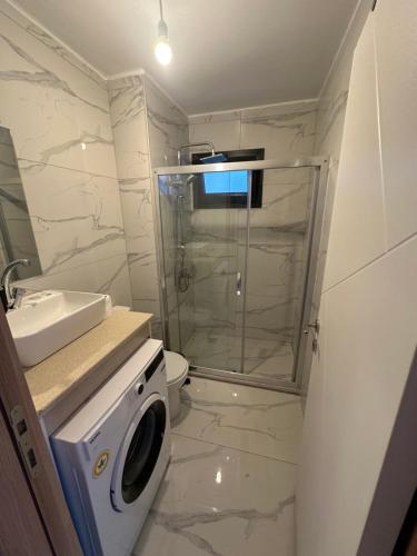 a bathroom with a shower and a washing machine at Sweet Home Turunc - Sea View Suites with One Bedroom in Turunç
