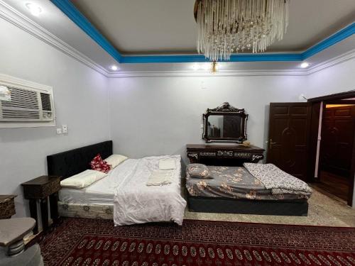 a bedroom with two beds and a mirror on the wall at شقة بغرفتين ودورتين في الدور الأول 7 دقائق للحرم in Al Madinah