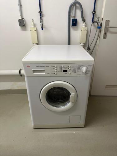a washing machine in a room next to a wall at Eastside am Kurpark in Timmendorfer Strand
