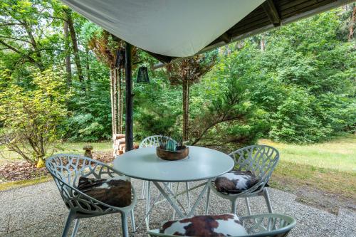 a table and chairs on a patio with trees at Ferienhaus Sonnenplatz Am See in Roding