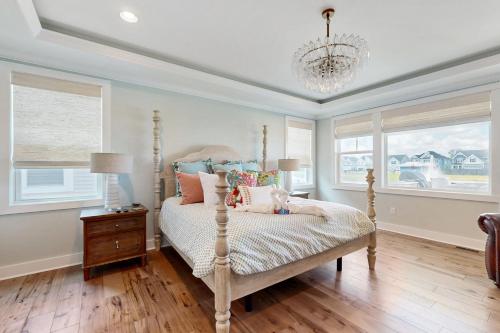 a bedroom with a bed and a chandelier at Marlin Chase --- 30340 Bermuda Dr in Ocean View