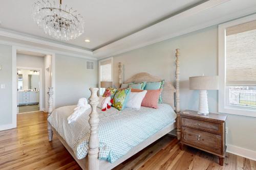 a bedroom with a bed and a chandelier at Marlin Chase --- 30340 Bermuda Dr in Ocean View