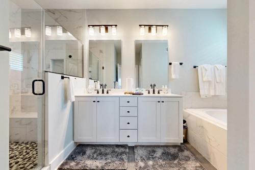 a white bathroom with two sinks and a tub and a shower at Marlin Chase --- 30340 Bermuda Dr in Ocean View