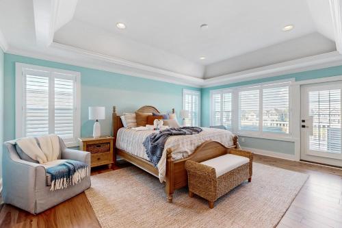 a bedroom with a bed and a chair and windows at Marlin Chase --- 30340 Bermuda Dr in Ocean View