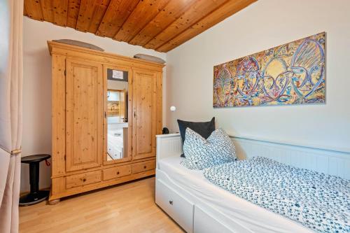 a bedroom with a bed and a wooden cabinet at Ferienhaus Sonnenplatz Am See in Roding